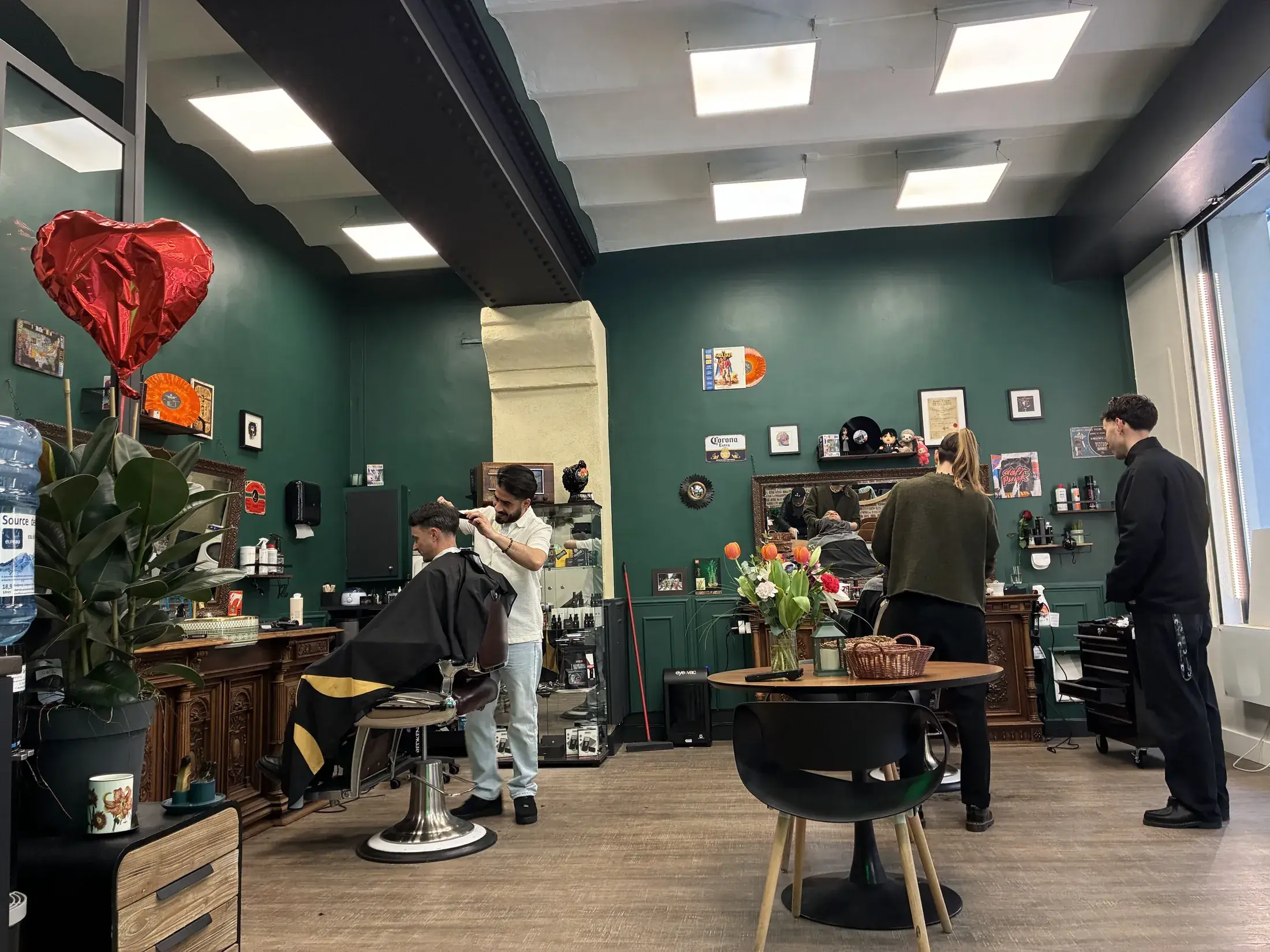La salle du salon CALM à Montpellier, murs vert profond et postes de coiffage