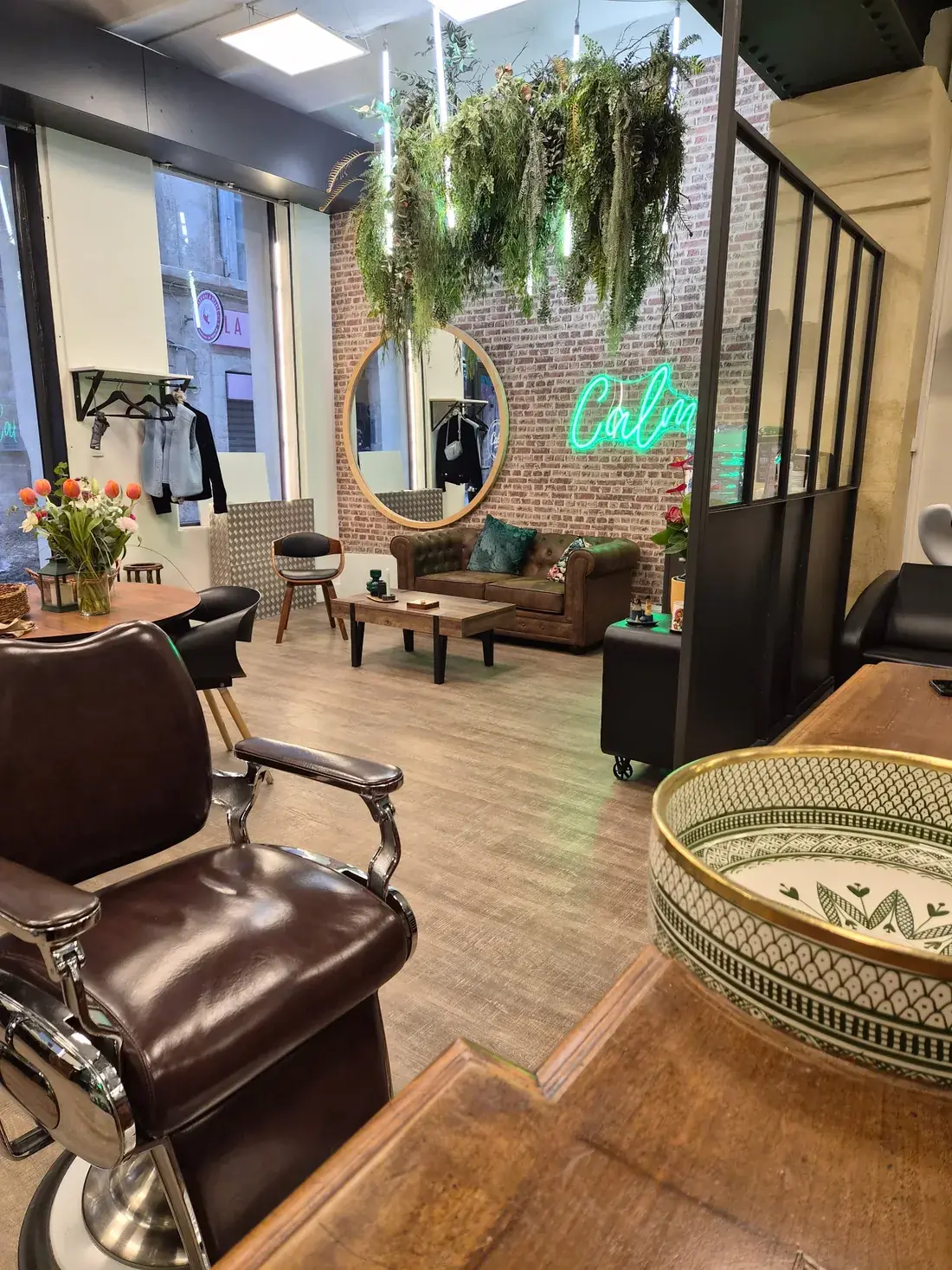 Le salon CALM à Montpellier : fauteuil de barbier, néon et mur de brique